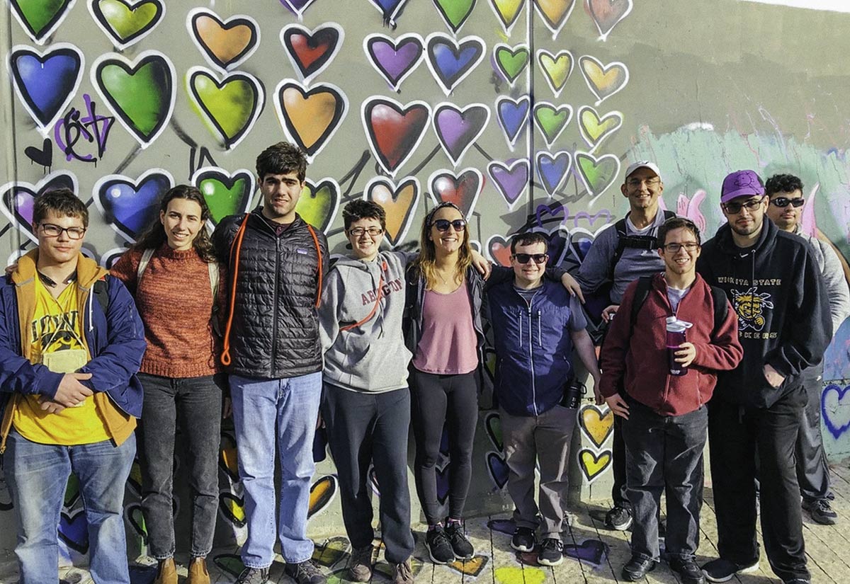 Jonah Geer with his Birthright Israel group in front of graffiti hearts in Tel Aviv