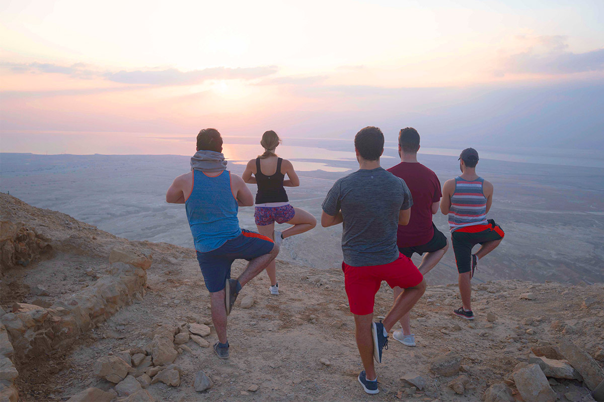 Birthright Israel participants doing yoga on a mountain.